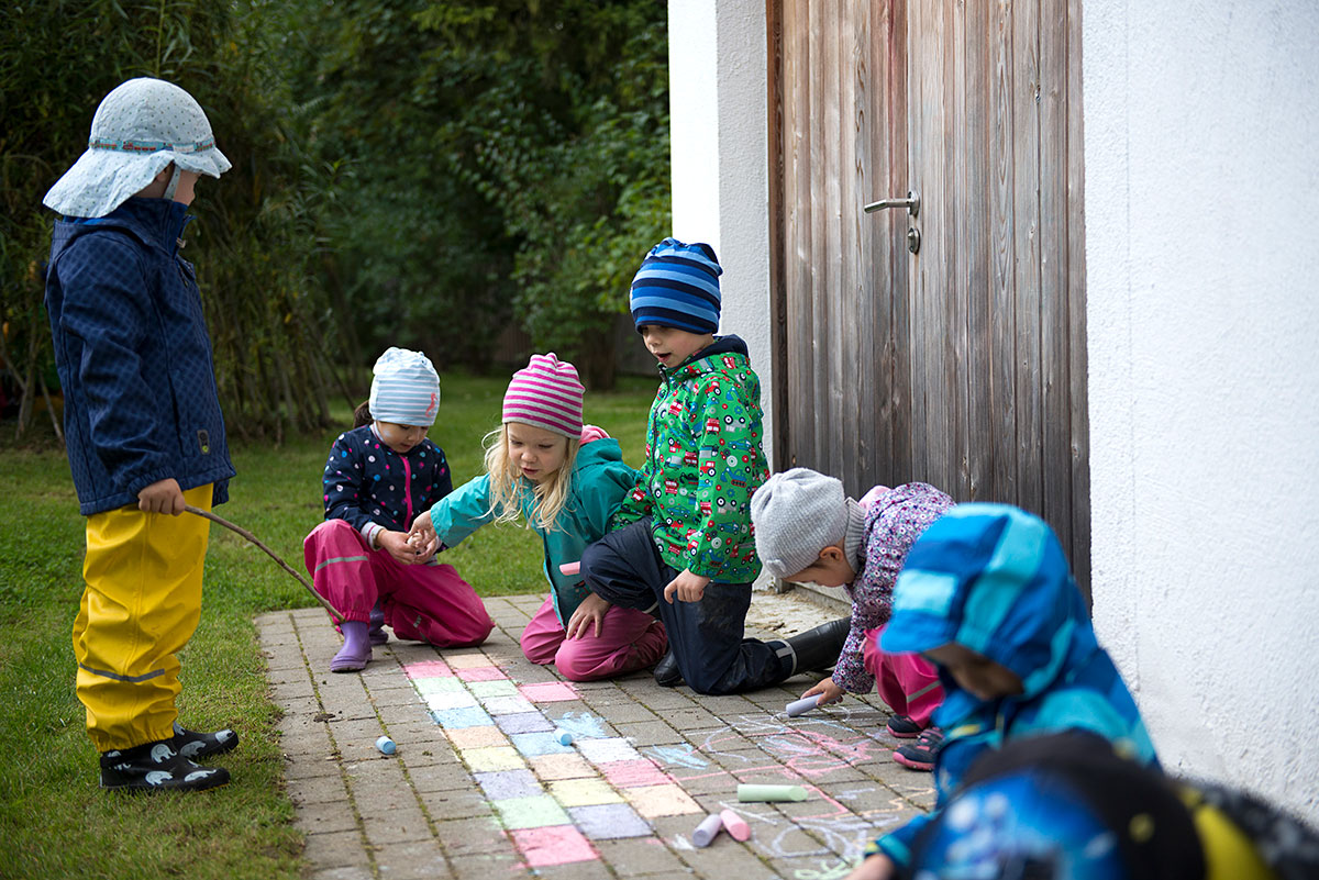 Kinder bemalen einen Boden mit Kreide - Kindergartenfotograf München | Felix Krammer Fotografie