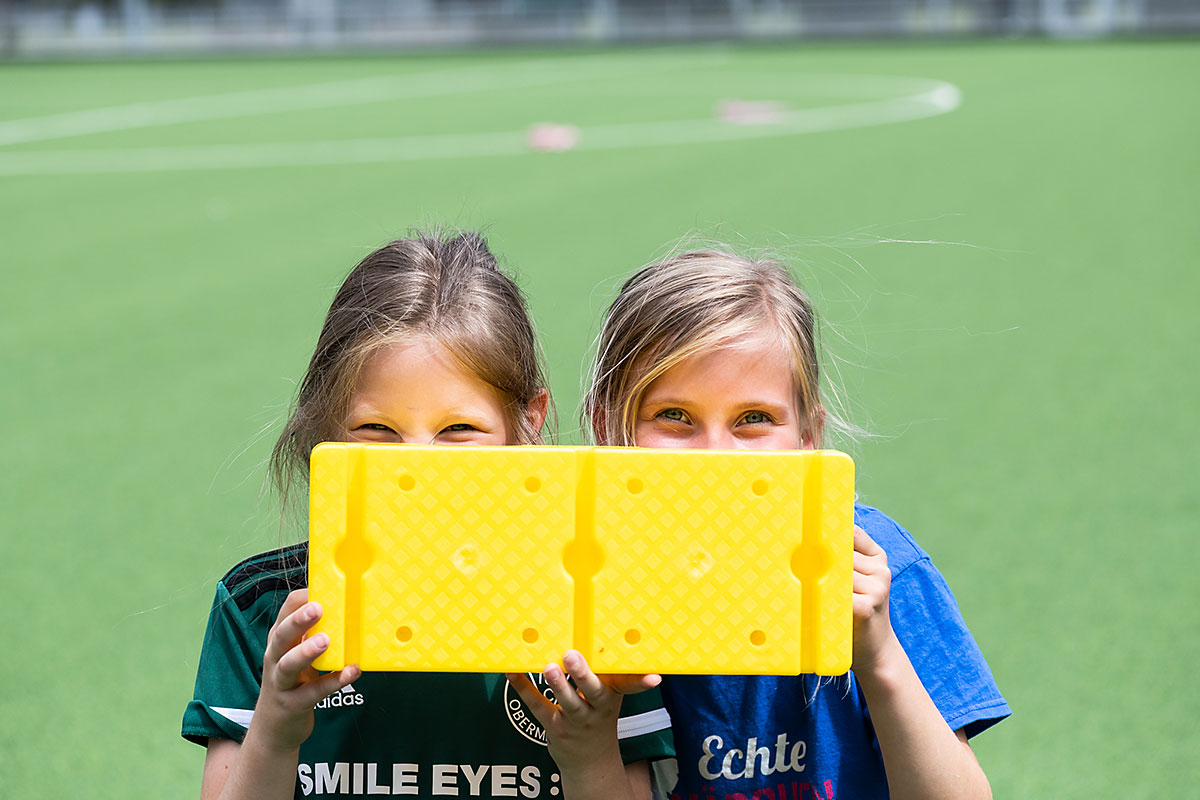 Kinderfotografie von 2 Grundschulkindern auf dem Sportplatz im Ganztag. | Felix Krammer Fotografie